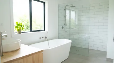 A white bathroom with a freestanding bath beside a glass walled shower