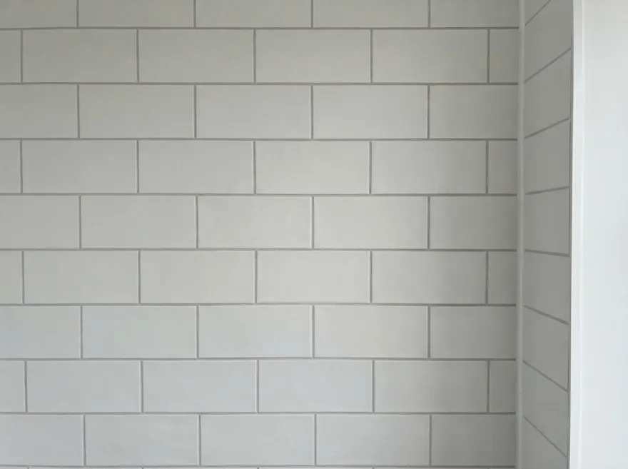 A white subway tile wall with fresh, even grout lines